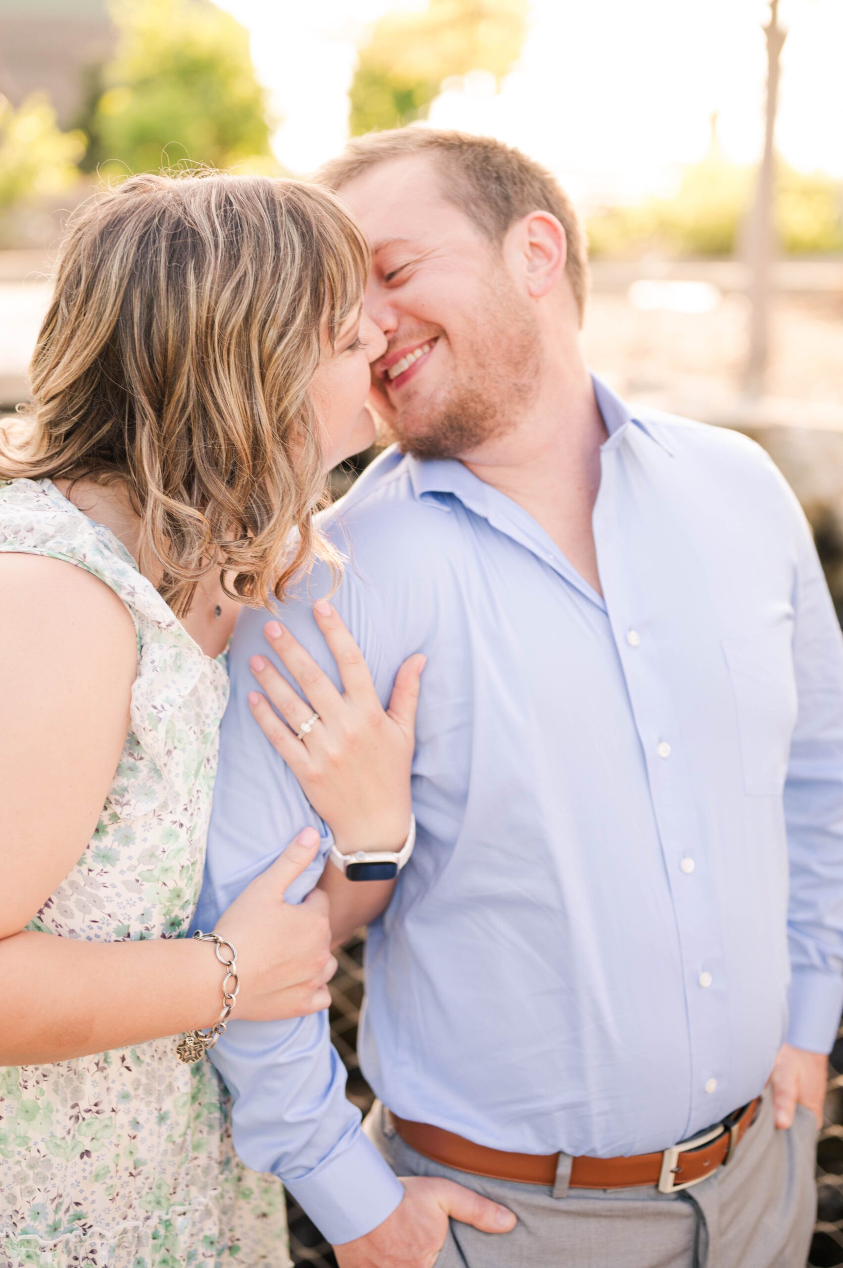 Couple kiss in front of a waterfall at Louisville's Waterfront Botanical Gardens for their engagement session