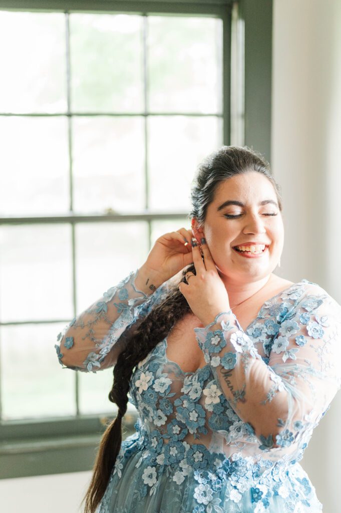 Bride putting in her earrings on her wedding day. 