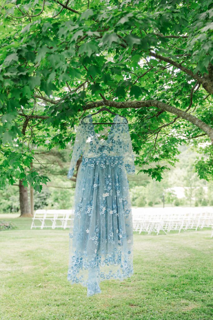 The bride's wedding dress hanging in front of the ceremony site. 