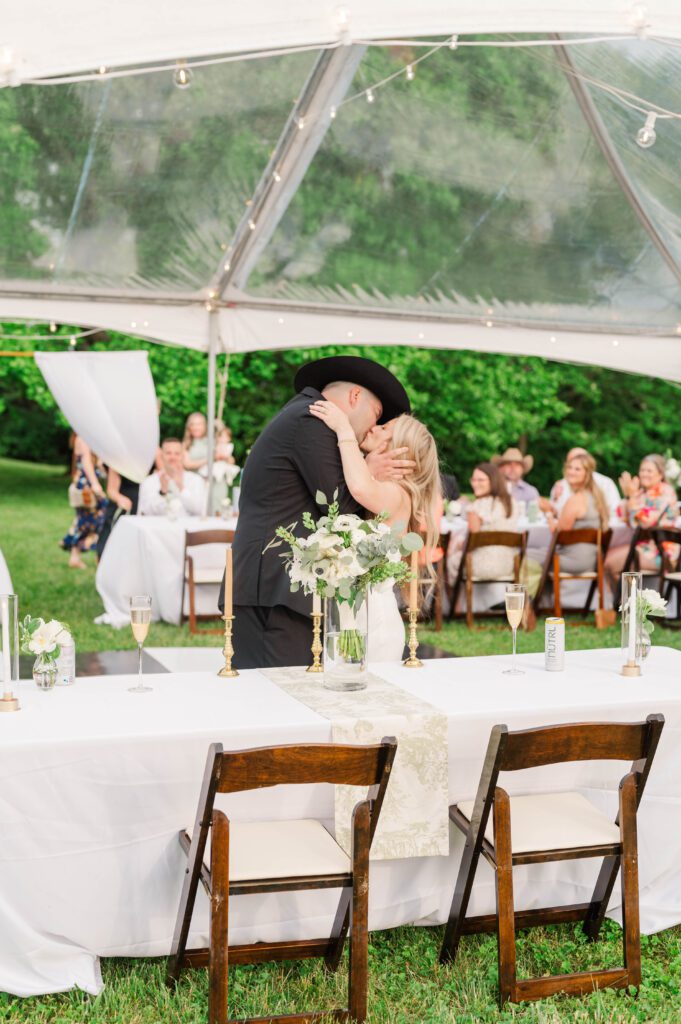 Bride and groom share a kiss at their wedding reception