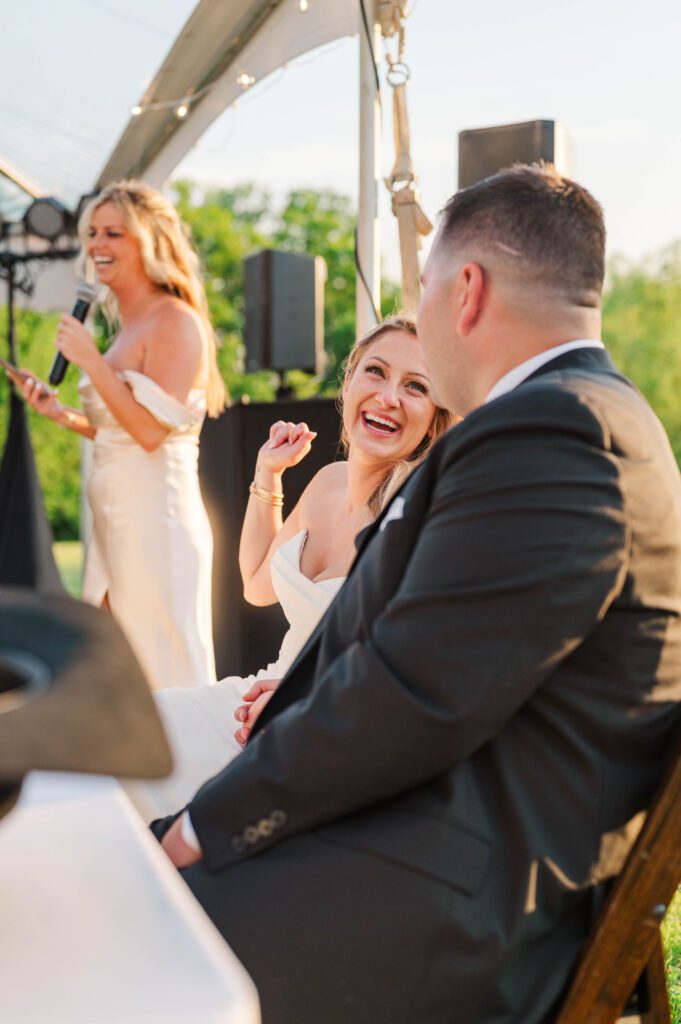 Bride and groom react to toasts given at their wedding reception