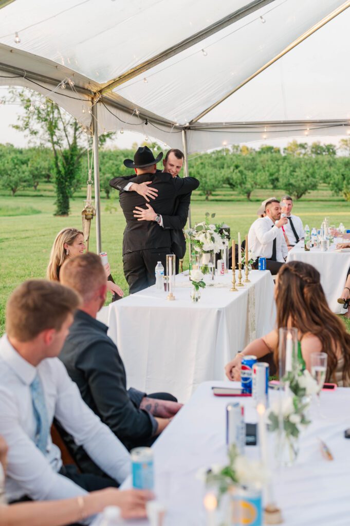 Bride and groom react to toasts given at their wedding reception