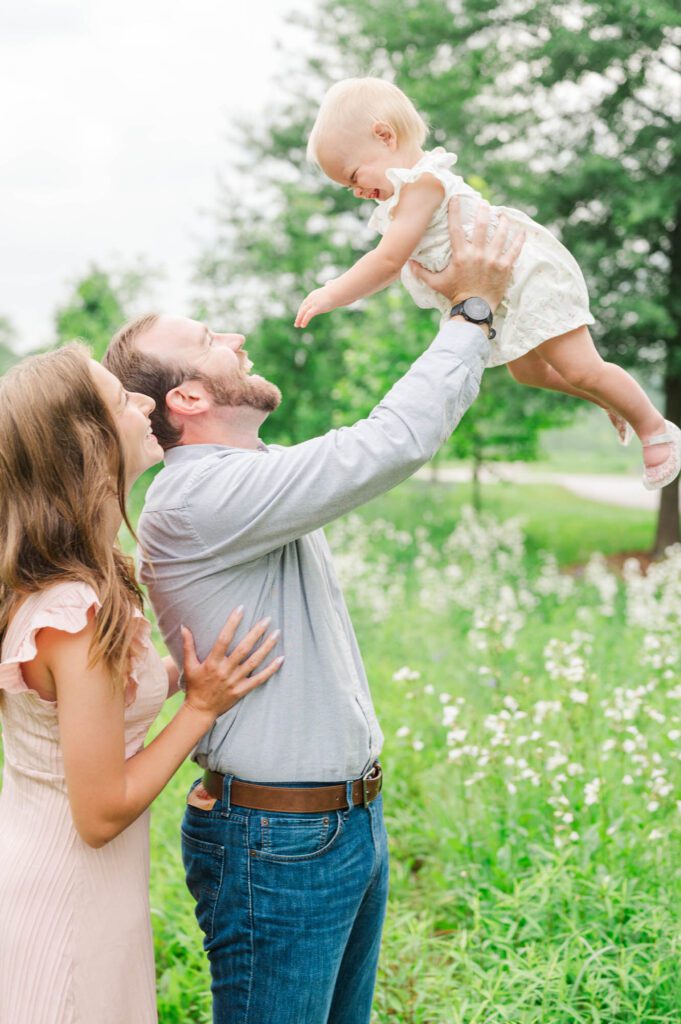 Dad lifts his daughter in the air