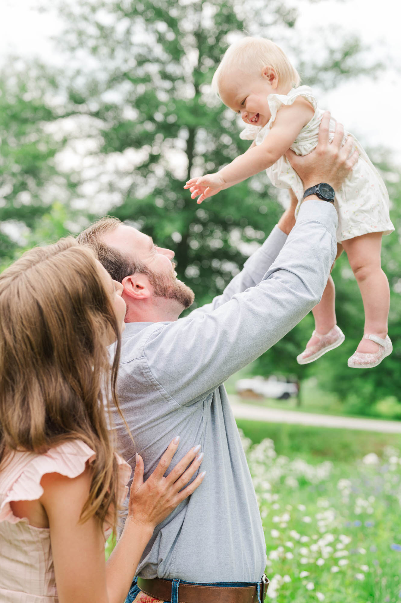 Mom and dad lift baby up in the air for their family photos