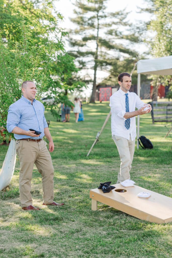 Guests playing cornhole during the reception of a Kentucky farm wedding. 