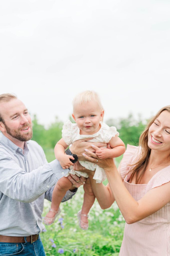 Mom and dad lift baby in the air