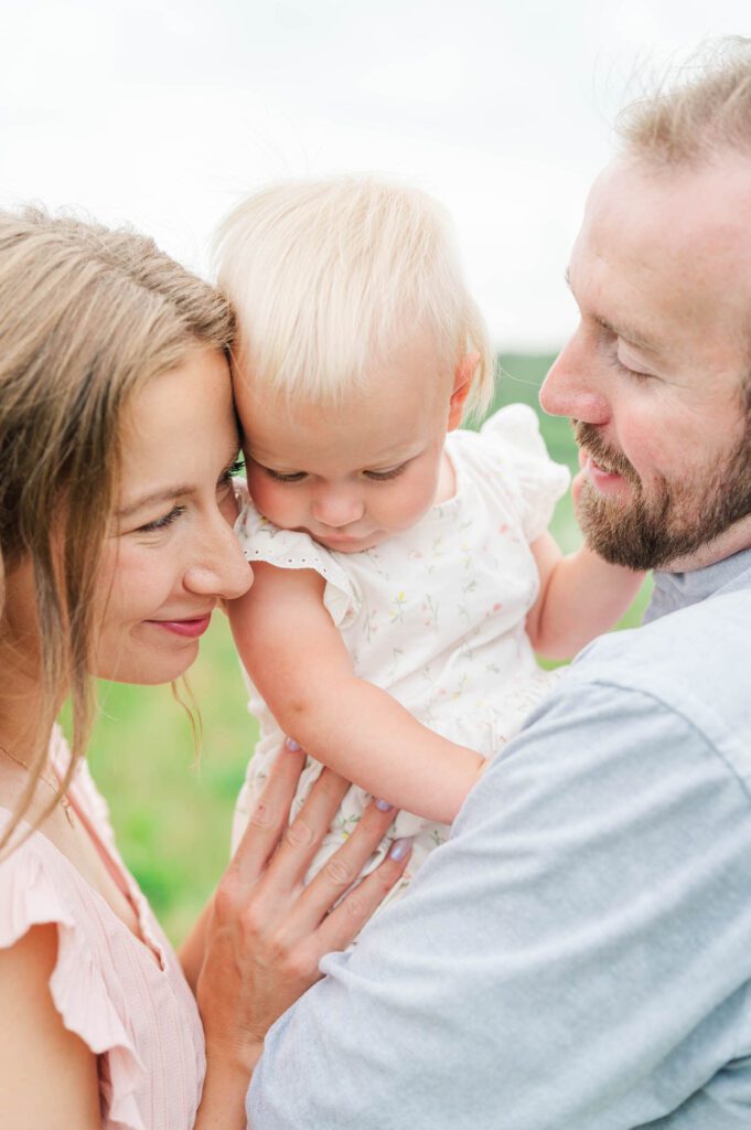 Mom and dad snuggle baby close during their family session