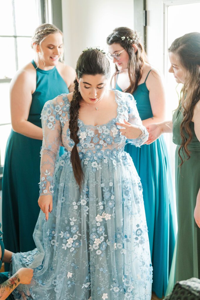 Bridesmaids helping the bride get ready on her wedding day. 