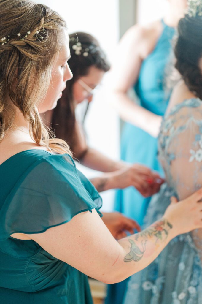 Bridesmaids helping the bride get ready on her wedding day. 