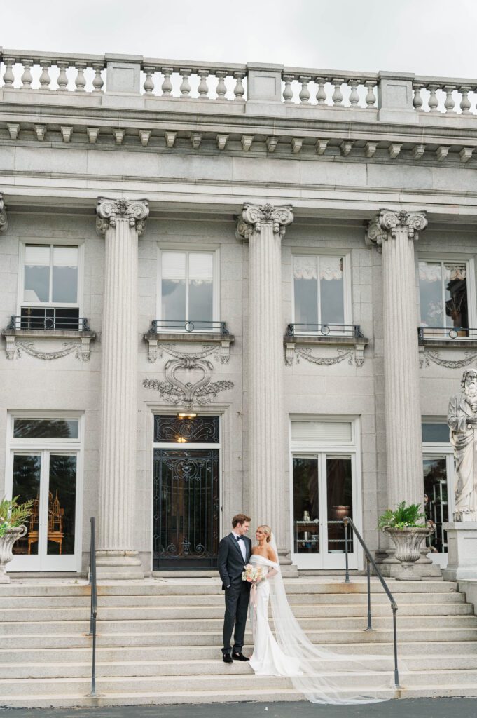 Bride and groom stand in front of Laurel Court for their wedding