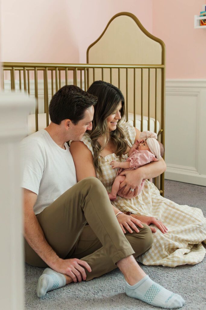 New mom and dad hold their baby girl in the nursery for their Louisville, KY in-home newborn session