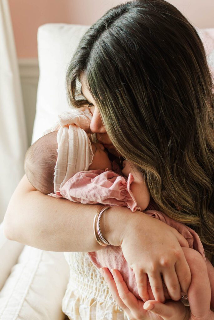 New mom holds her baby girl in the nursery 