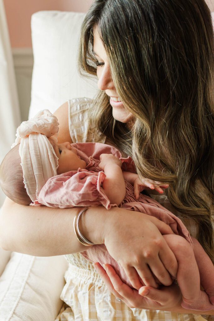 New mom holds her baby girl in the nursery 