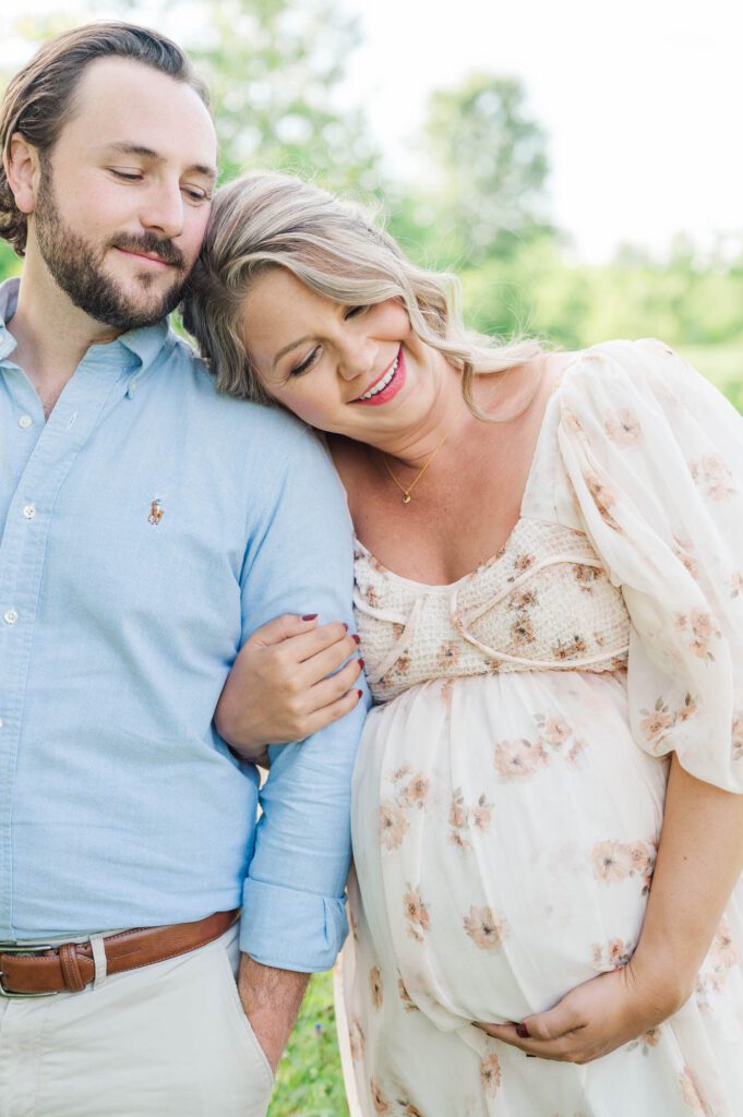 Couple stands together in wildflower field for their maternity photo session at Beckley Creek Park in Louisville