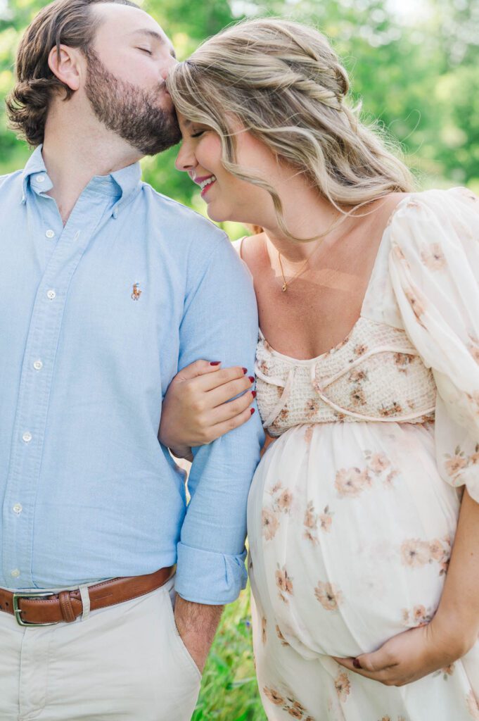 Couple stands together in wildflower field for their maternity photo session at Beckley Creek Park in Louisville