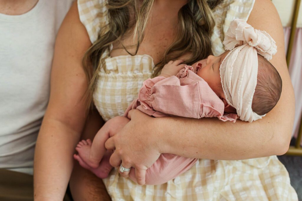 New mom and dad hold their baby girl in the nursery for their Louisville, KY in-home newborn session