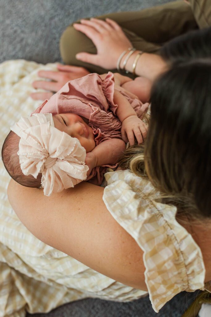 New mom and dad hold their baby girl in the nursery for their Louisville, KY in-home newborn session