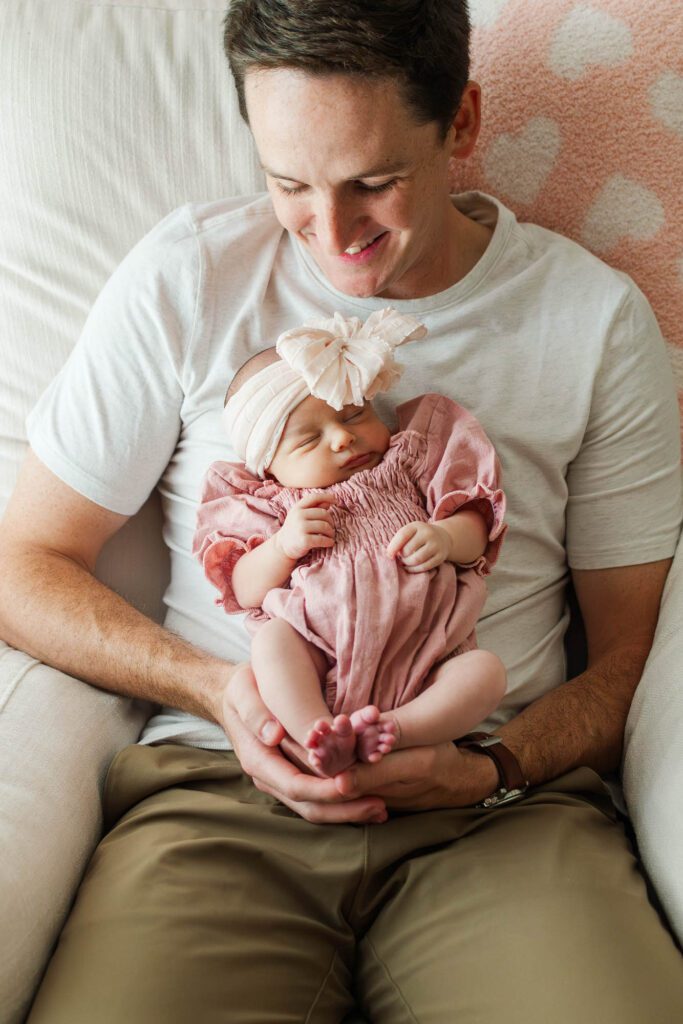 New dad holds his baby girl in the nursery 