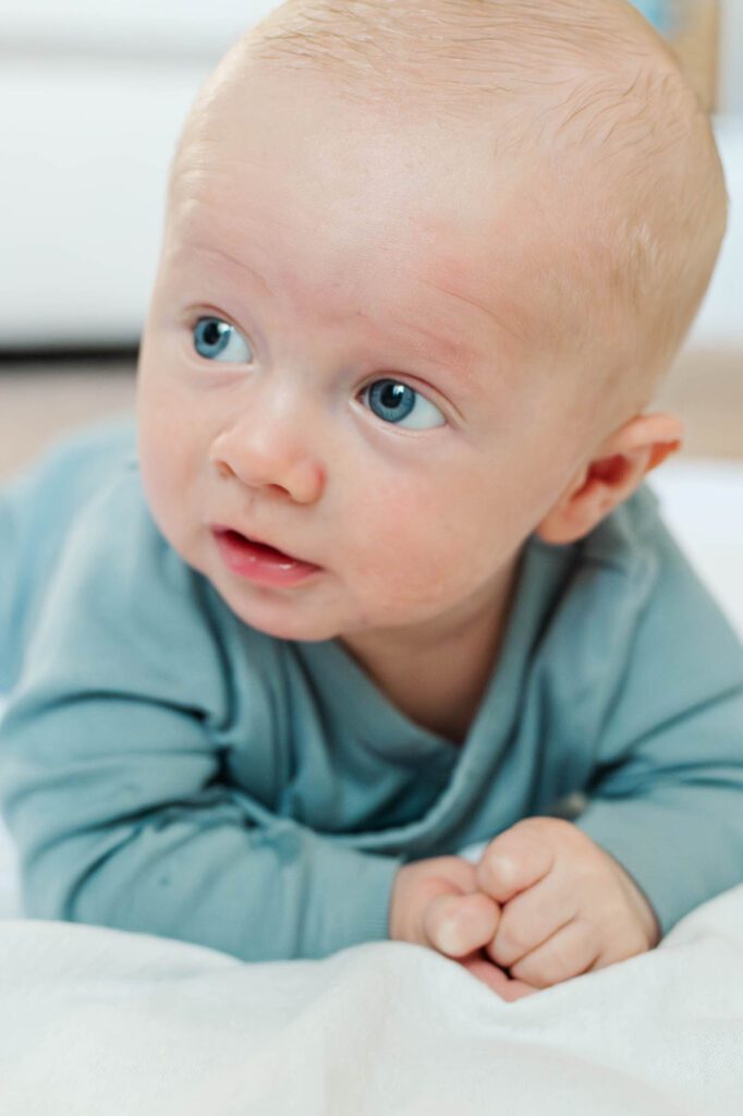 Baby plays in tummy time for in-home family session in Louisville, KY