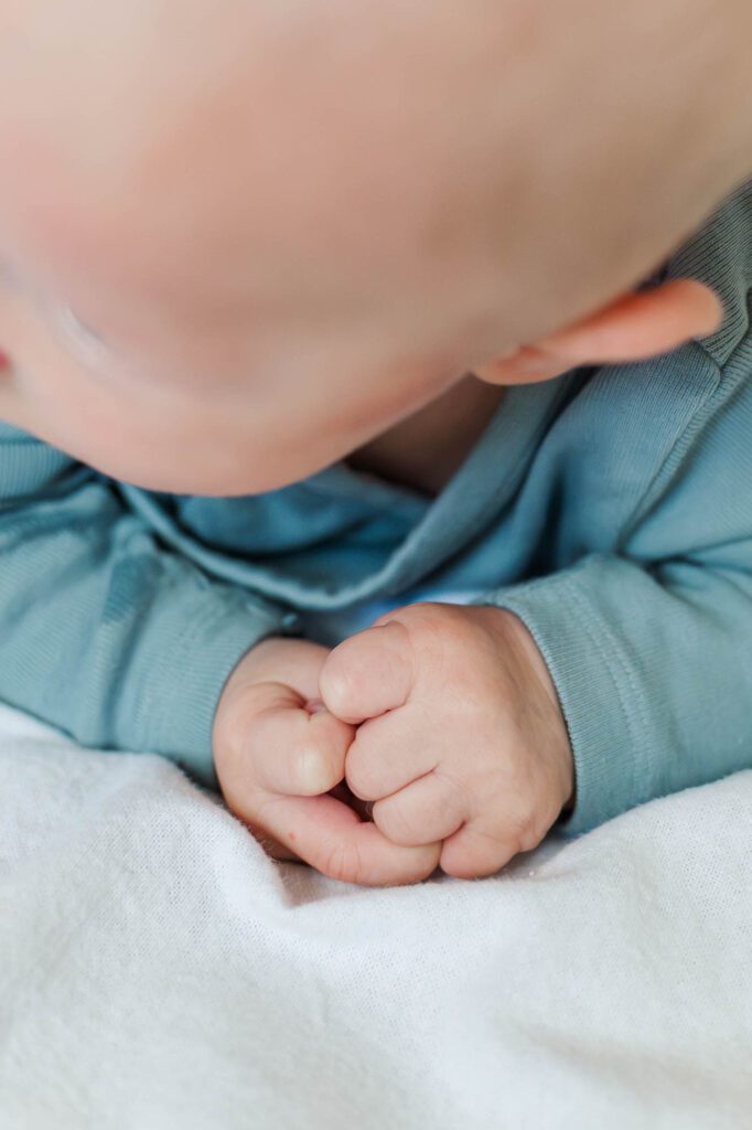 Baby plays in tummy time for in-home family session in Louisville, KY