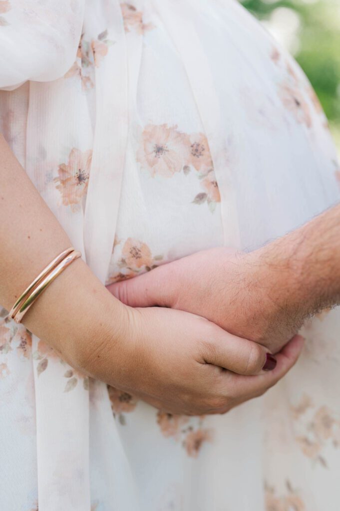 A close up of couple's hands on baby bump for their maternity session