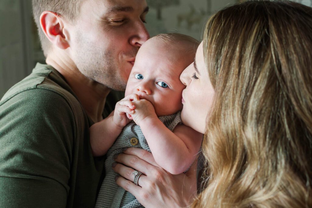 Family stands together in the nursery with their 3 month old for their Louisville in-home family session