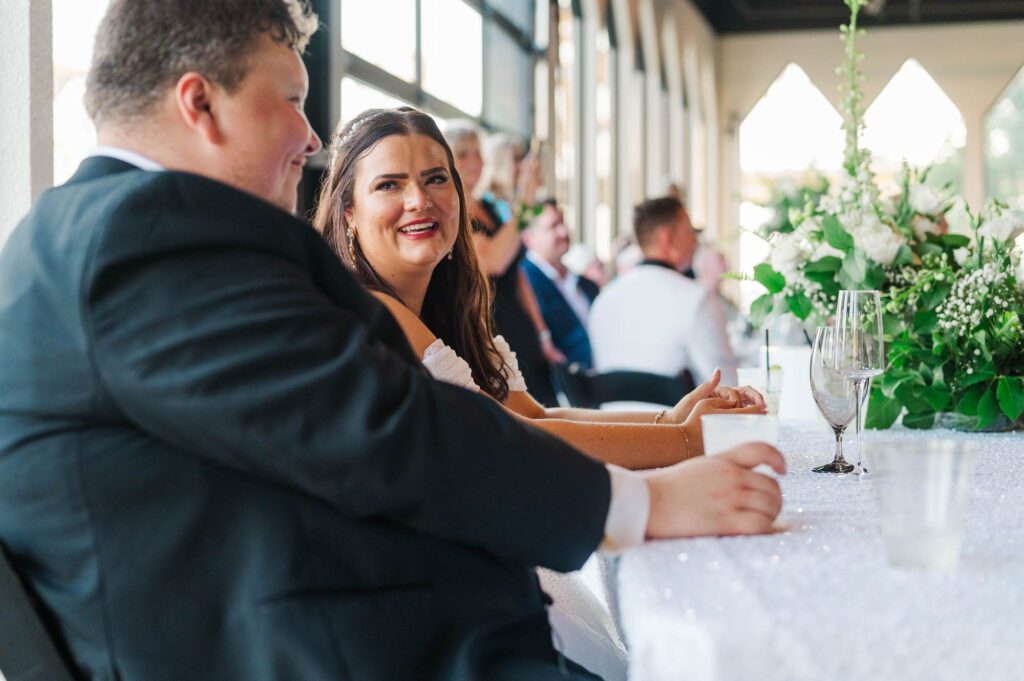 Bride and groom look at each other during the speeches on their wedding day