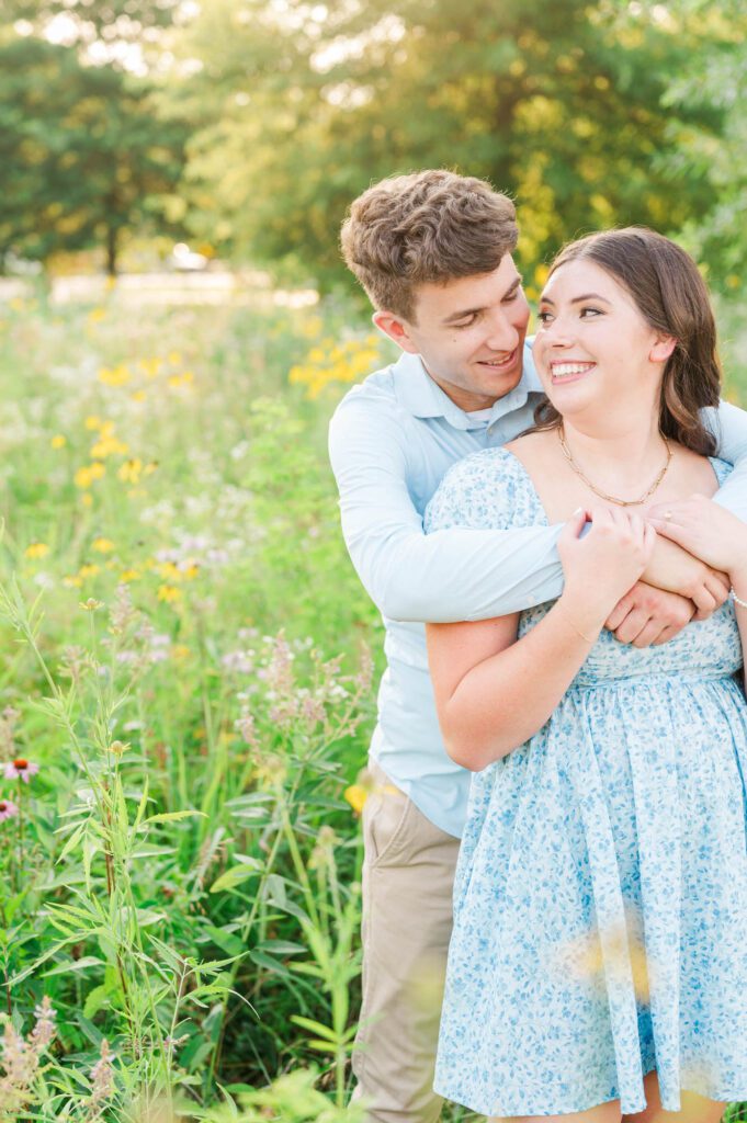 Couple stands together in a field of wildflowers at Beckley Creek Park for their Louisville engagement session.