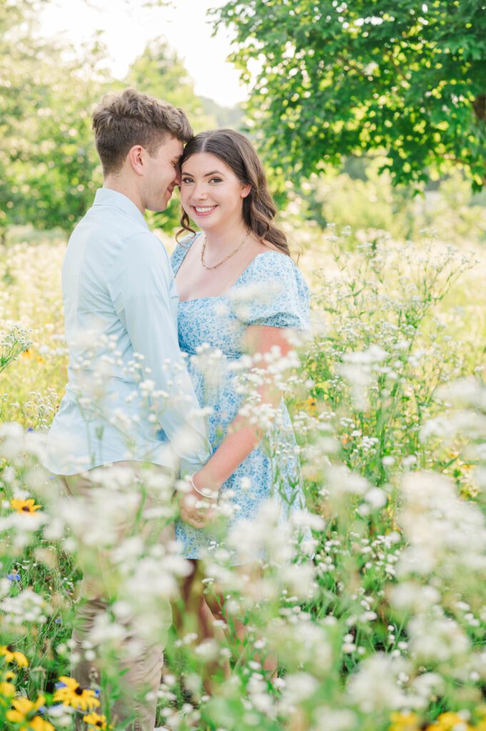 Couple stands together in a field of wildflowers at Beckley Creek Park for their Louisville engagement session.