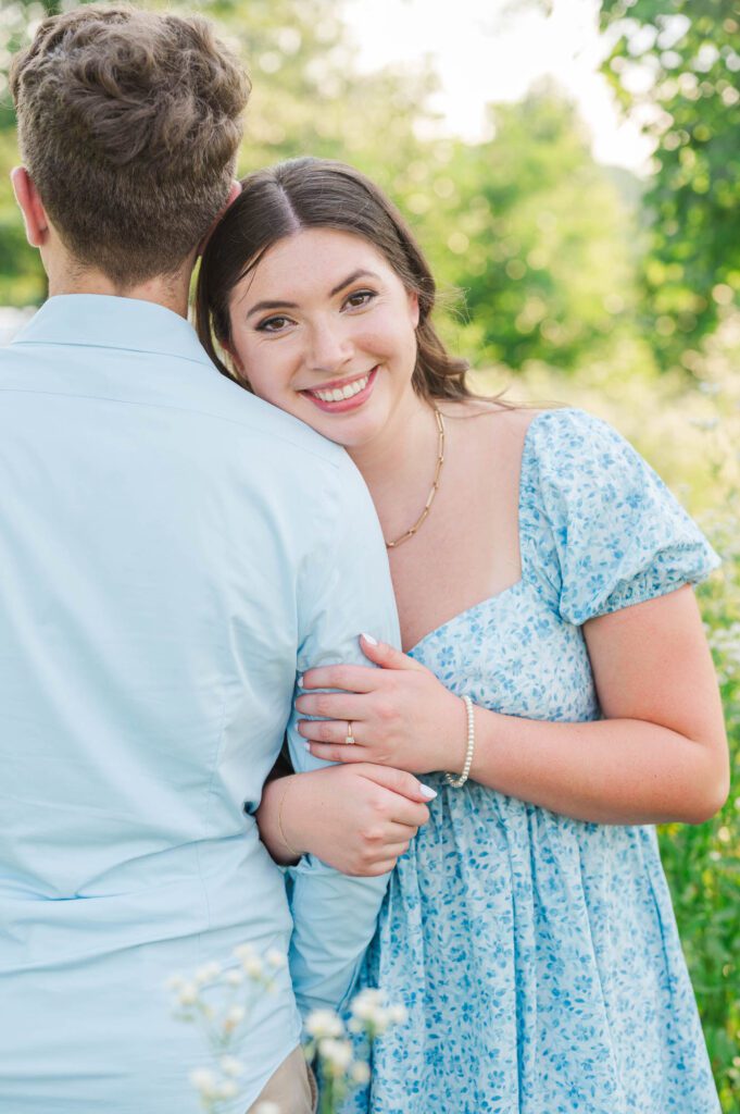 Couple stands together in a field of wildflowers at Beckley Creek Park for their Louisville engagement session.