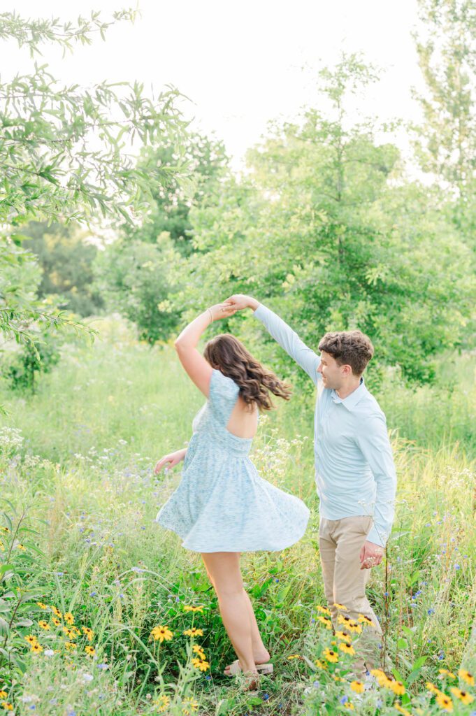 Couple twirls in a field of wildflowers