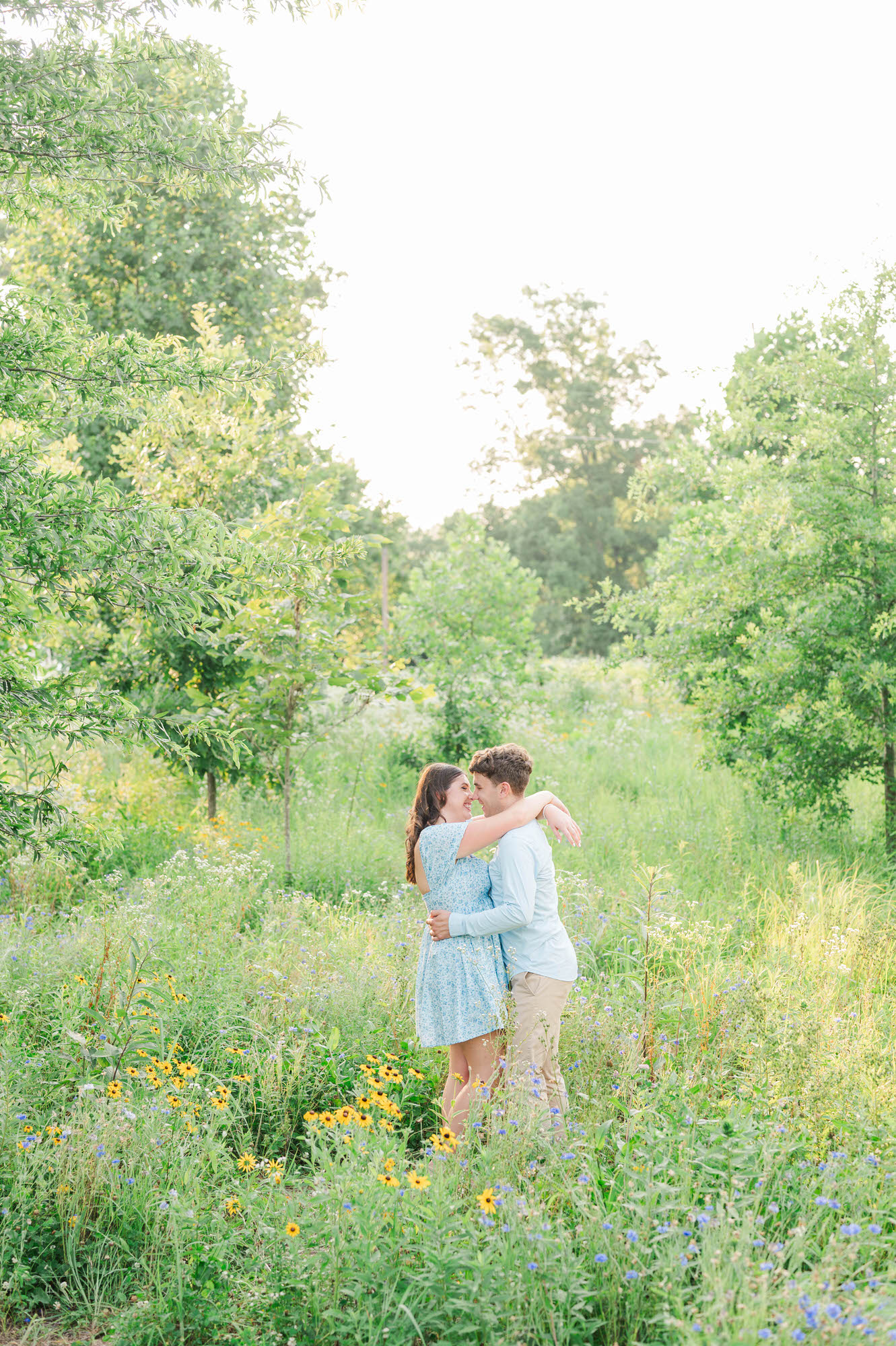 Couple stands together in a field of wildflowers at Beckley Creek Park for their Louisville engagement session.