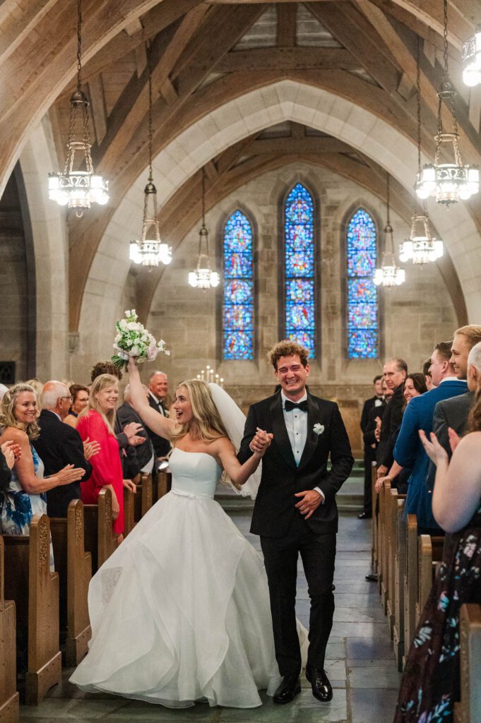 Bride and groom celebrate as they walk down the aisle after being married