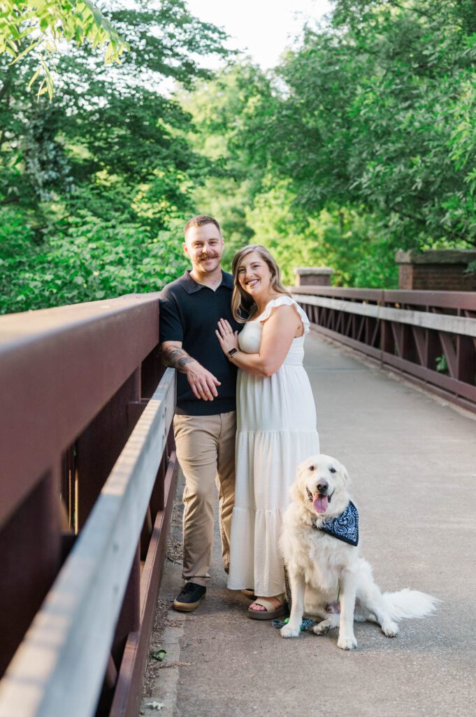 A Louisville couple smiles at the camera with their dog