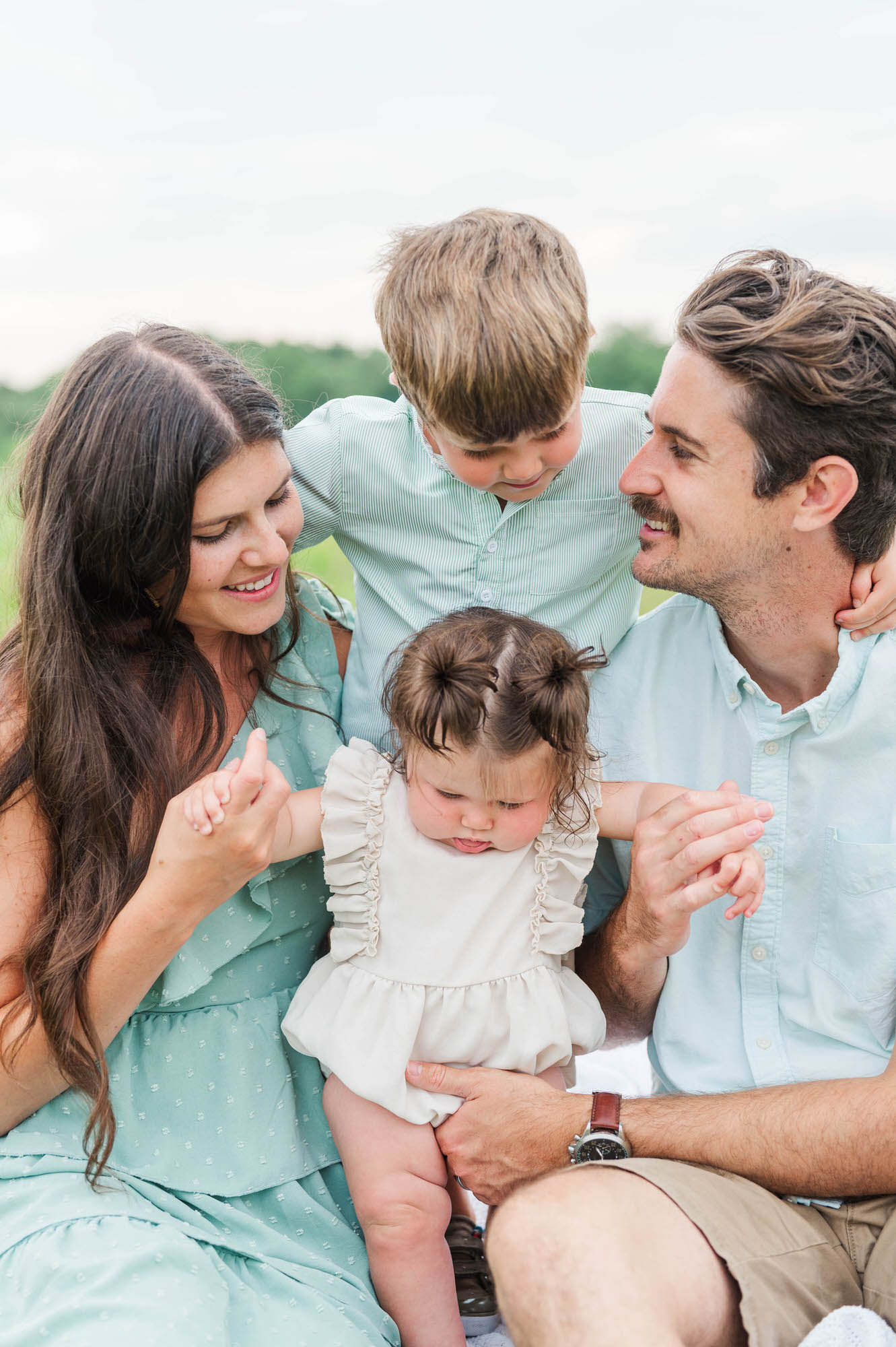 Family sit together for their photo session in Beckley Creek Park in Louisville, KY