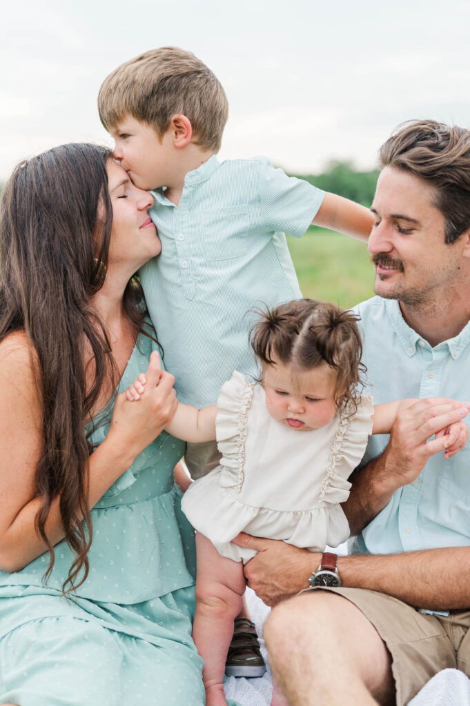 Son gives mom kisses during their family photo session in Louisville