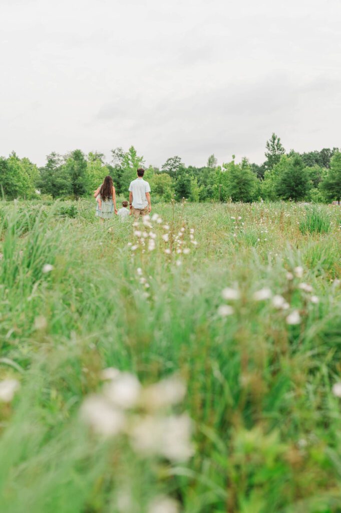 Family walks through field of wildflowers at Beckley Creek Park in Louisville, KY