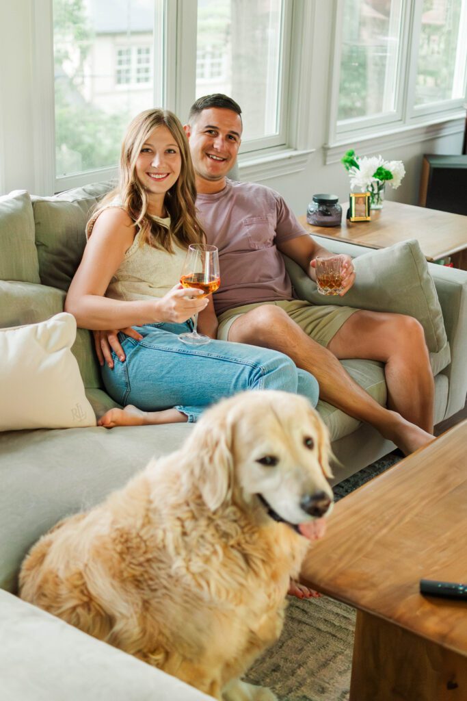 Couple sits together on their couch for their in-home couples session in Louisville, KY