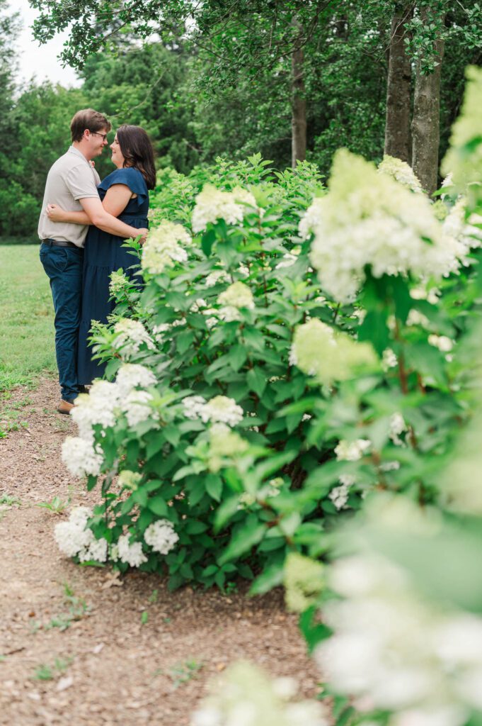 Couple stands amongst flowers at Yew Dell Botanical Gardens for their couples session in Louisville, KY