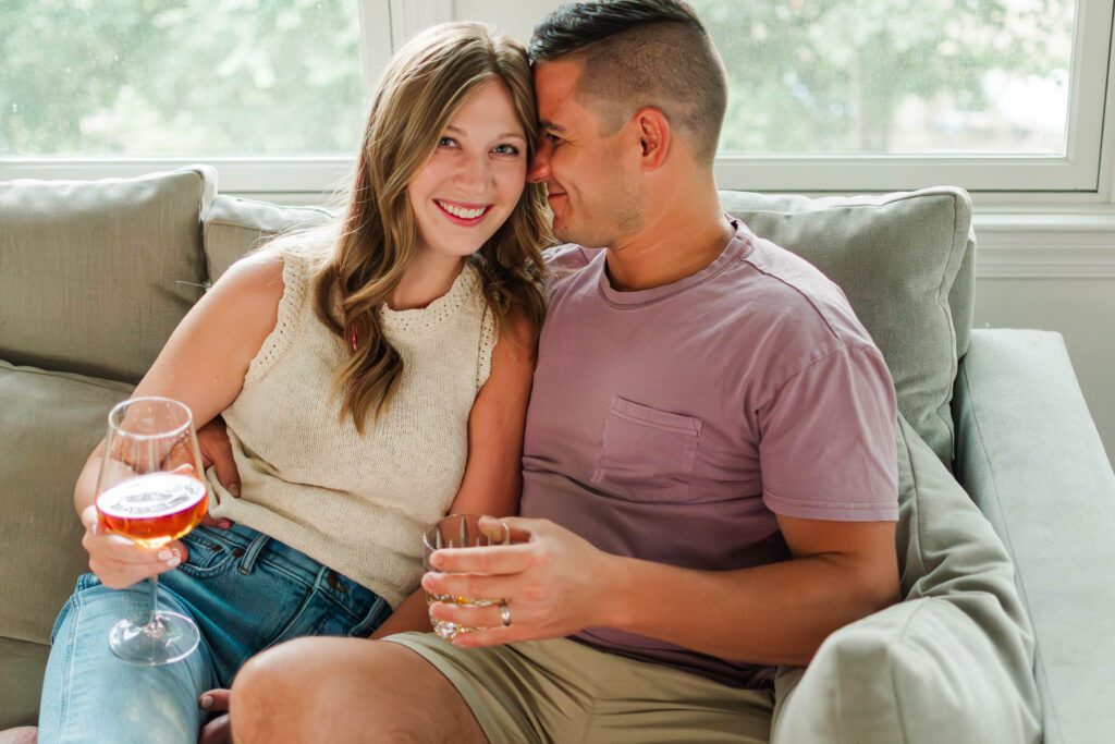 Couple sits together on their couch for their in-home couples session in Louisville, KY