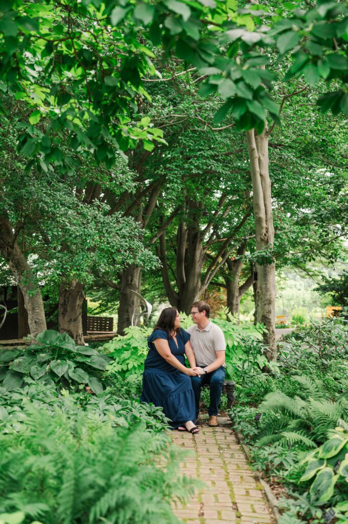 Couple sits amongst flowers at Yew Dell Botanical Gardens for their couples session in Louisville, KY