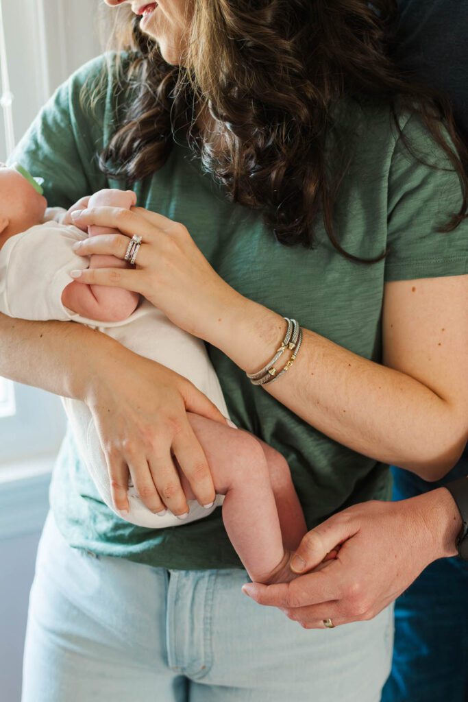 New parents hold their baby girl for their Louisville newborn photography session