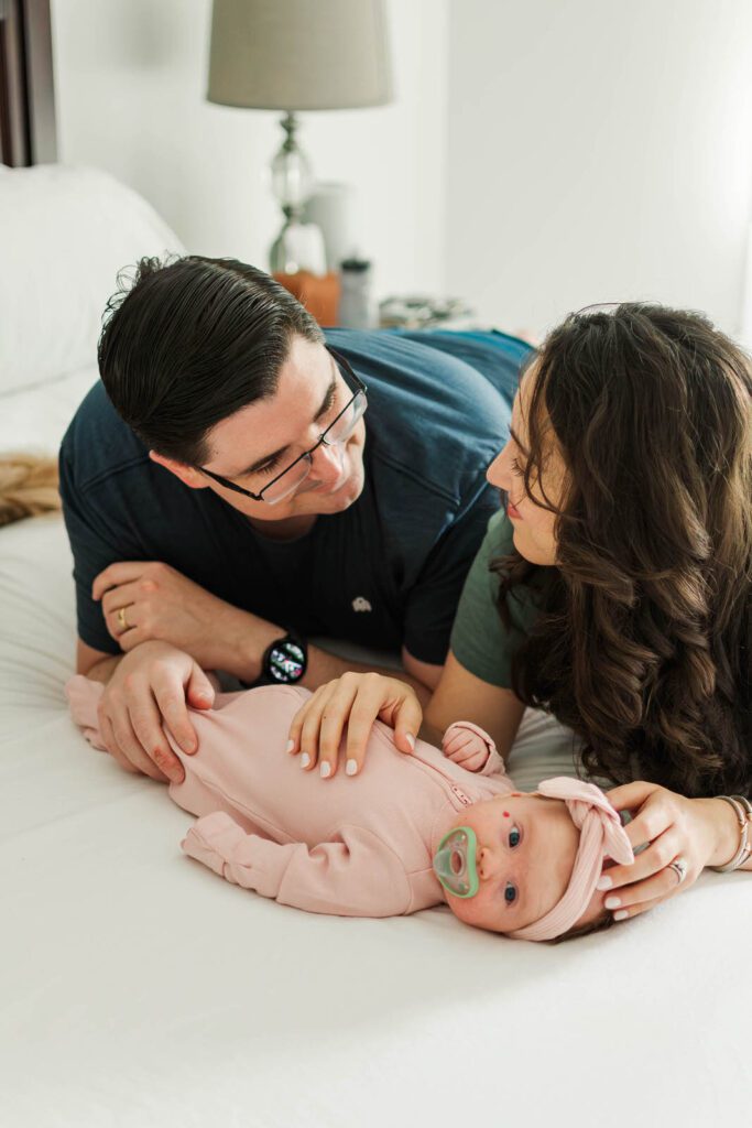 Parents smile down at their newborn baby girl