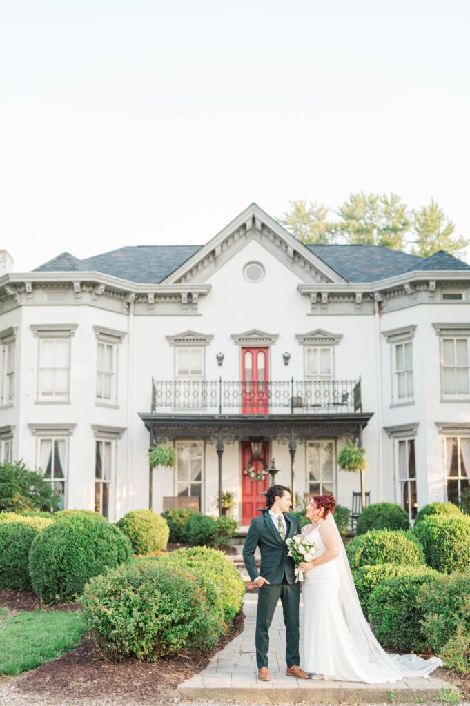 Bride and groom stand in front of Richwood on the River on their wedding day