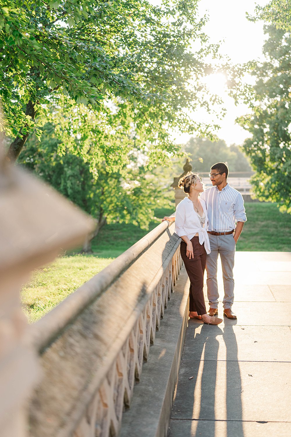 Couple standing at the entrance to the Crescent Hill Reservoir for their engagement session