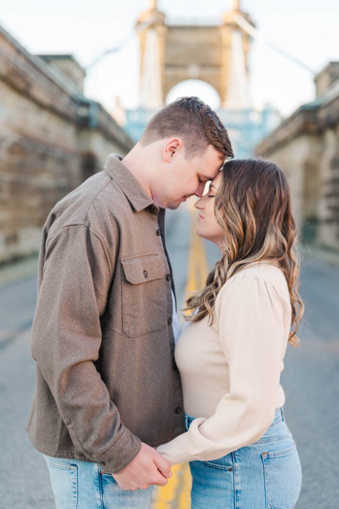 Couple stands together at Roebling Bridge for their Cincinnati engagement photos