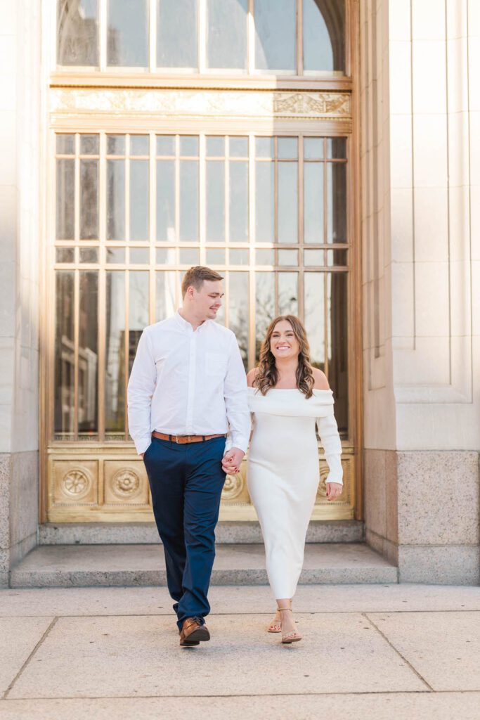 Couple walks in front of the Hamilton County Courthouse for their engagement session