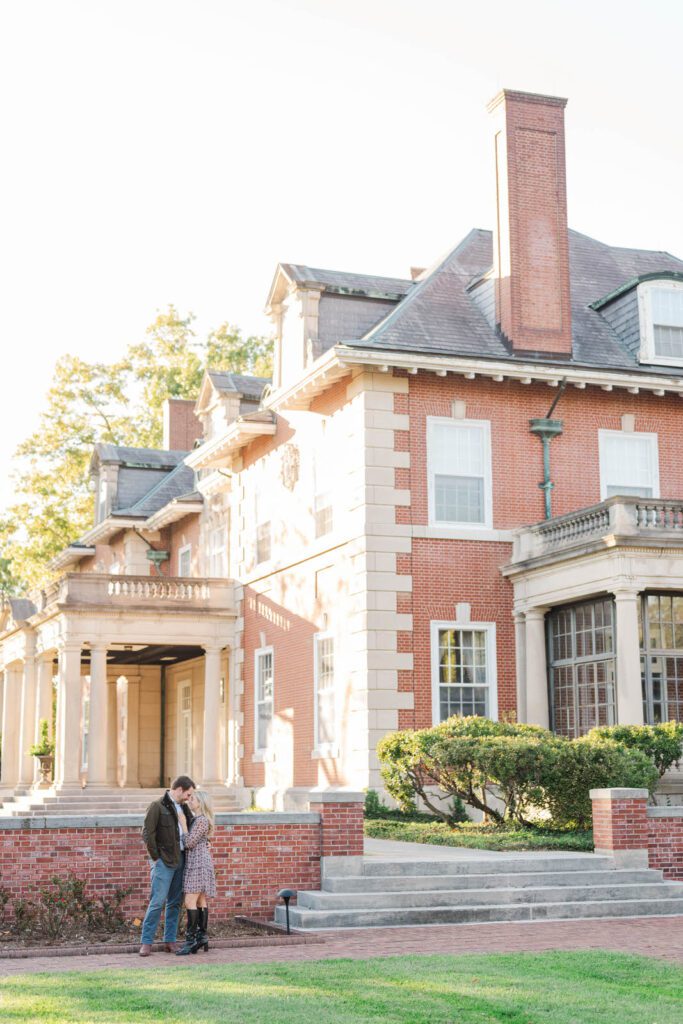 Couple stands together in front of Gardencourt in Louisville for their engagement session