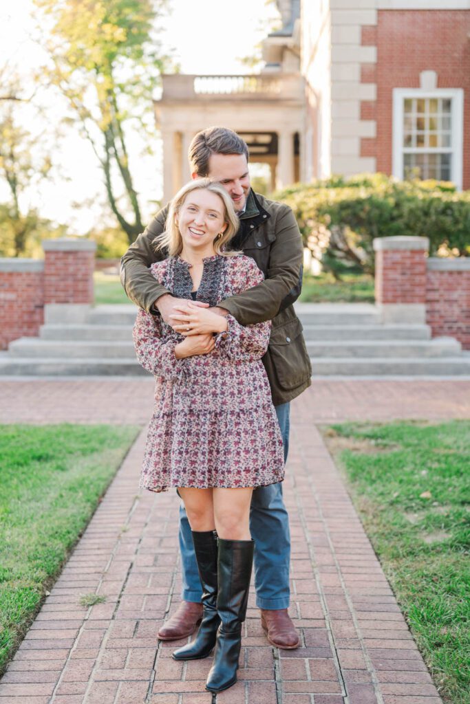 Couple laughs together in front of Gardencourt in Louisville for their engagement session