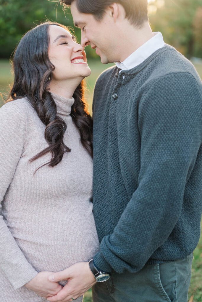 Parents-to-be smile during their maternity session at Cherokee Park